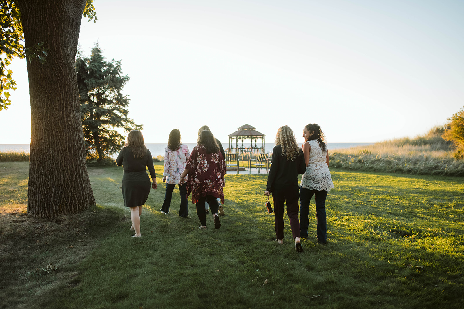 Retreat group walking toward the lakeside gazebo at golden hour