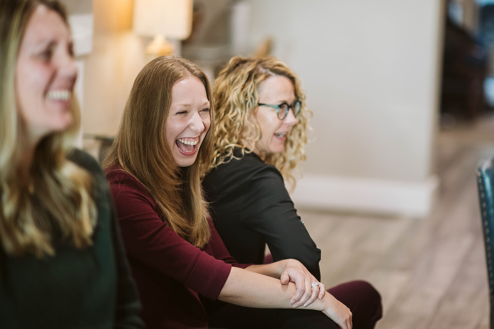 Retreat participants laughing together in a warmly lit living room