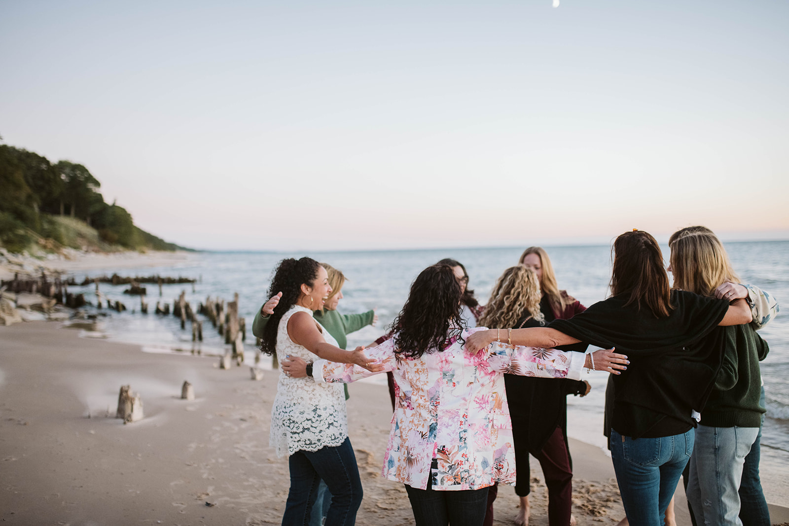Retreat circle with arms around each other looking out at Lake Michigan